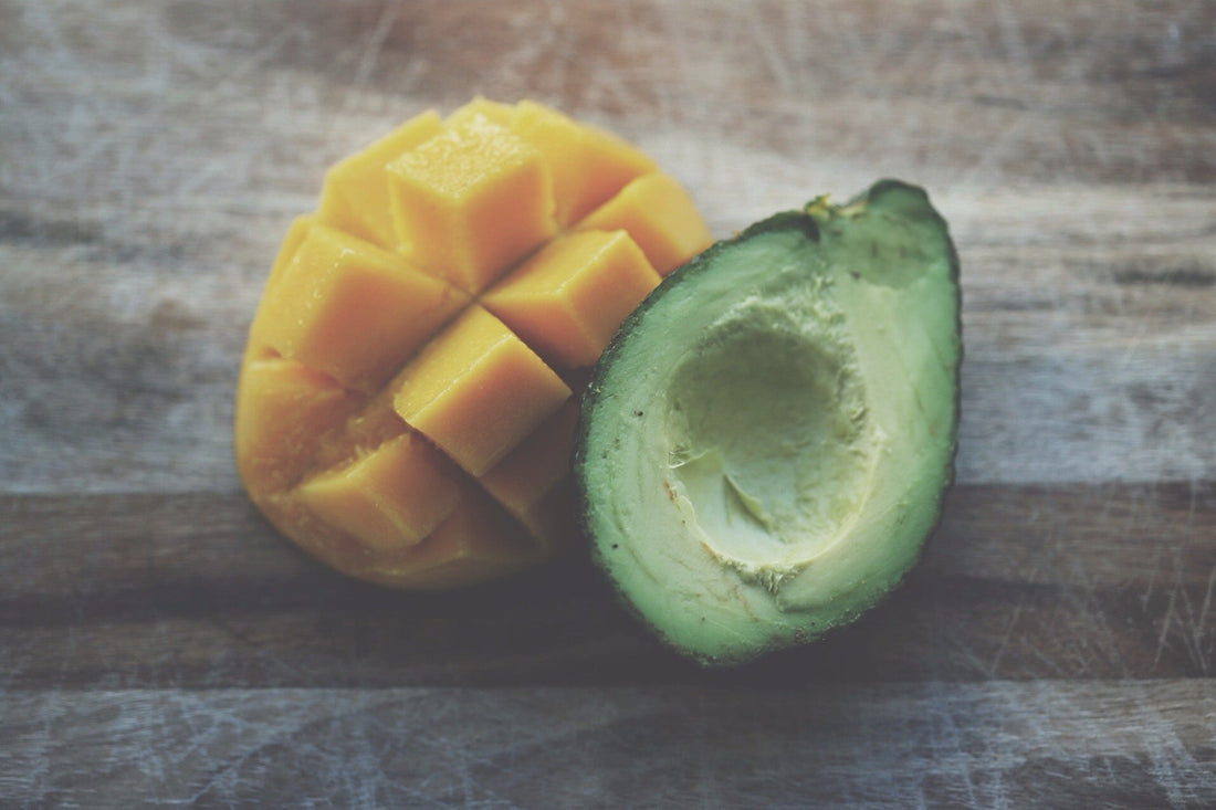 Avocado and mango on the dark surface